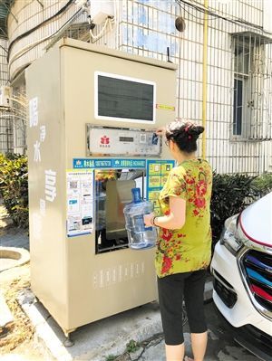 5月24日，瓊山區(qū)上丹花苑小區(qū)居民陳女士在使用共享凈水機(jī)取水。 本報(bào)記者 陳歆卓 攝